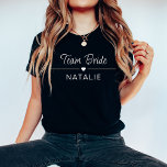 Junggeselinnen-Abschied Team Bride Personalisiert  T-Shirt<br><div class="desc">Mit unserem Personalisierten Bridal-T - Shirt in Bridal-Junggeselinnen-Abschied in eleganter, dunkler Farbe mit auffallenden, weißen Druckgrafiken stärken Sie Ihren Stil. Diese dunkelfarbenen Shirts, die für die Braut und ihre Truppe entworfen wurden, verleihen Ihrer Feier eine Touch von Eleganz und sorgen gleichzeitig für Spaß und Einheit. Das Herzmotiv nimmt die Bühne...</div>