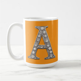 Juwelenbesetzter Buchstabe A auf gelbem Hintergrun Kaffeetasse