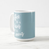 Kaffee ist ein Umarmer in einer Tasse Mute Blue Ta (Vorderseite Links)