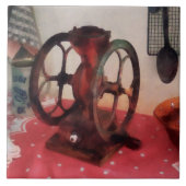 Kaffeemühle auf roter Tischdecke Fliese (Vorderseite)