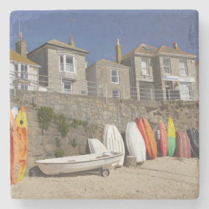 Kajaks und Dinghien, die an der Wand des Meeres Steinuntersetzer