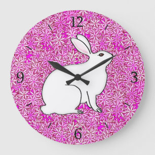 Kaninchen auf einem Bett mit Frühlingsblumen Große Wanduhr