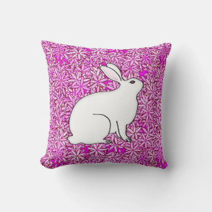 Kaninchen auf einem Bett mit Frühlingsblumen Kissen
