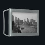 Kansas City Urban Skyline, Schwarz-Weiß-Foto Rechteckige Gürtelschnalle<br><div class="desc">In Kansas City, Missouri, erstreckt sich die sechsspurige Hauptstraße von der unteren rechten Ecke des Schwarz-Weiß-Fotos in Richtung des miessigen Wolkenkratzer-Horizonts in der Ferne. Ein dunkler Limousine, unterhalb und links von der Mitte, fährt senkrecht zu den Fahrspuren und schafft einen Moment der Intrige in der Stadtumgebung. Um das Foto Downtown...</div>