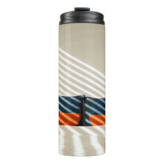 Karierte, schwarzweiße Textilien auf weißem Bett Thermosbecher