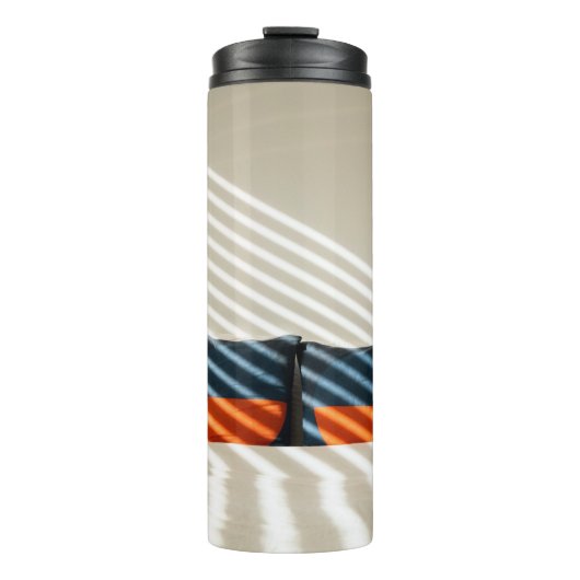 Karierte, schwarzweiße Textilien auf weißem Bett Thermosbecher (Vorderseite)