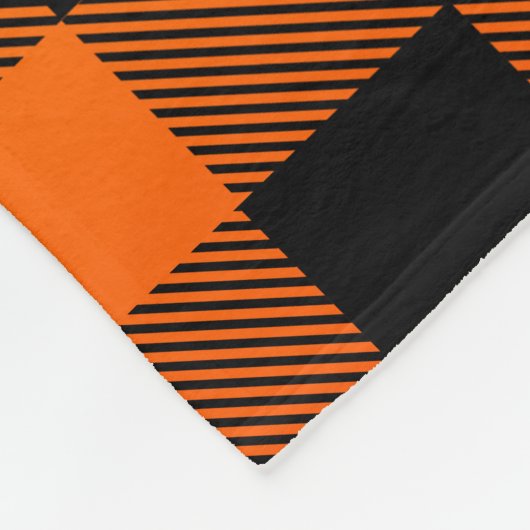 Kariertes Schwarzes bis orangefarbenes Muster Fleecedecke (Ecke)