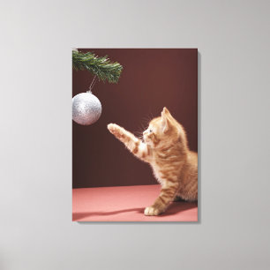 Kätzchen, das mit Weihnachtsflitter auf Baum Leinwanddruck
