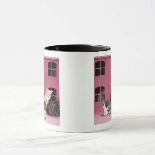 Kätzchen im Haus der Puppe Tasse (Zentrum)