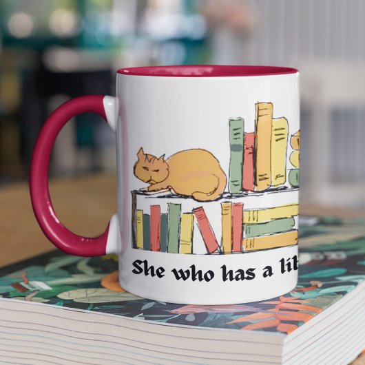 Katze auf der virtuellen Bibliothek, die von Hand  Kaffeetasse