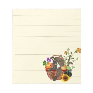 Katze in einem Korb aus Kürbis und Blume Notizblock