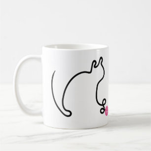 Katze in einer Linie spielt mit rosa Garnball Kaffeetasse