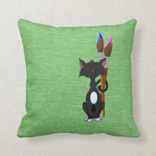 Katze mit farbigen Pinseln auf grün Kissen