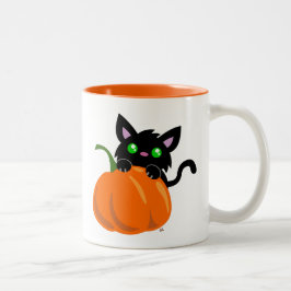 Katze und eine Tasse für den Kürbis