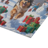 Keeshond Hund läuft im Schnee mit Weihnachtshut Schneidebrett (Ecke)