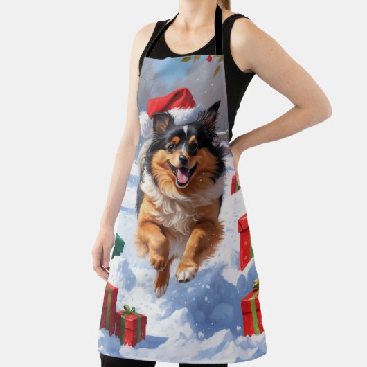 Keeshond Hund läuft im Schnee mit Weihnachtshut Schürze (InSitu)