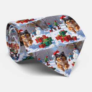 Keeshond-Hund läuft im Schnee mit Weihnachtsmütze Krawatte