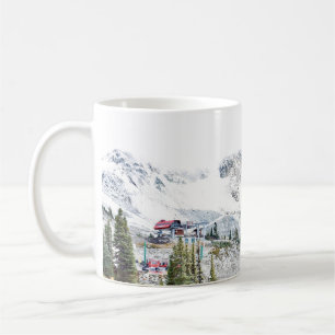 KIEFERNBÄUME IN DER NÄHE EINES MIT SCHNEE BEDECKTE KAFFEETASSE