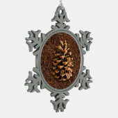 Kiefernkone auf gefallenen Nadeln Schneeflocken Zinn-Ornament (Links)