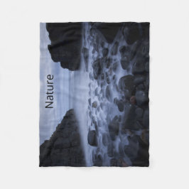 Kiesel und Felsen entlang der Küste des Ozeans Fleecedecke