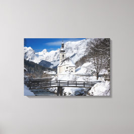 Kirche im Schnee mit den Alpen Leinwanddruck