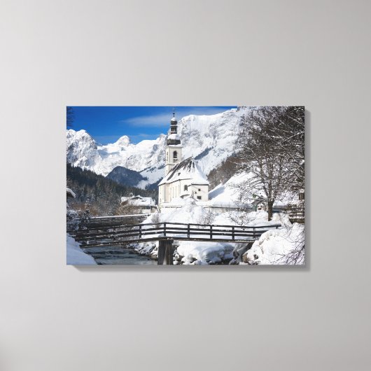 Kirche im Schnee mit den Alpen Leinwanddruck (Vorderseite)