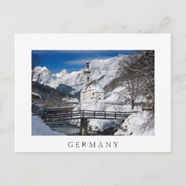 Kirche im Schnee mit den Alpen Postkarte