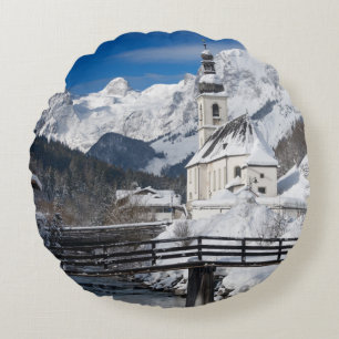 Kirche im Schnee mit den Alpen Rundes Kissen