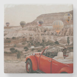 Klassischer roter Oldtimer beim Beobachten von Hei Steinuntersetzer
