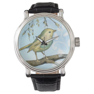 Kleiner gelber Vogel hockte auf einer Armbanduhr