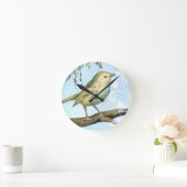 Kleiner gelber Vogel hockte auf einer Runde Wanduhr (Zuhause)