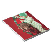 Kleiner Junge, der einen Hund schmückt Notizblock (angewinkelt)