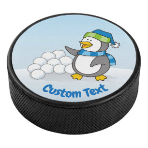 Kleiner Pinguin mit schneebedeckten Kugeln Eishockey Puck