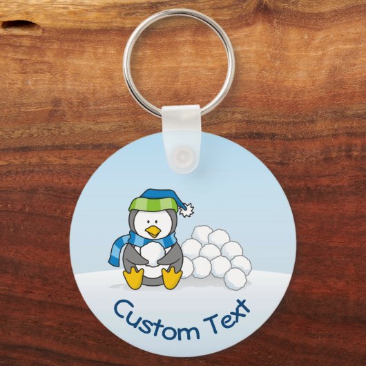 Kleiner Pinguin sitzend mit Snowballs Schlüsselanh Schlüsselanhänger (Vorderseite)