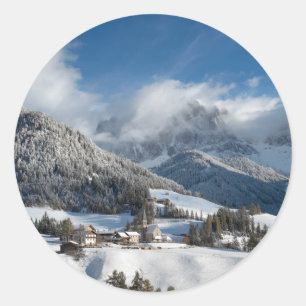 Kleines Dorf mit Dolomitbergen im Schnee Runder Aufkleber