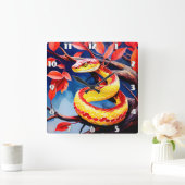 Kobra mit lebendiger rot-gelber Waage in Baumkrone Quadratische Wanduhr (Zuhause)