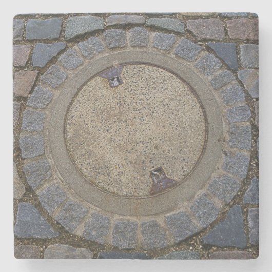 Kopfsteinpflasterstraße mit Manhole, grau-braun Steinuntersetzer (Vorderseite)