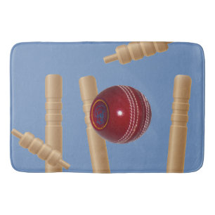 Kricketball auf Blau zerschmettert Kricketstumps, Badematte