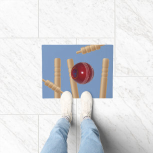 Kricketball auf Blau zerschmettert Kricketstumps, Fußmatte