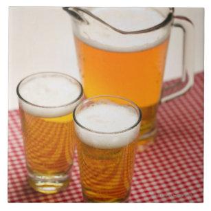 Krug Bier und zwei Gläser füllte mit Bier Fliese