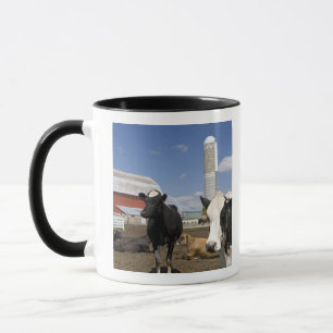 Kühe vor einer roten Scheune und einem Silo auf ei Tasse