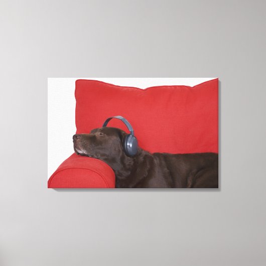 Labrador mit Kopfhörer auf dem Sofa Leinwanddruck (Vorderseite)