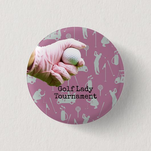 Lady Golfer hält Golfball auf pinklem Hintergrund Button (Vorderseite)