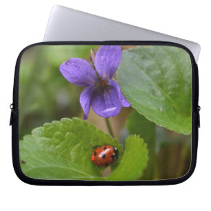 Ladybug über süße Violettsorten-Blume Laptopschutzhülle