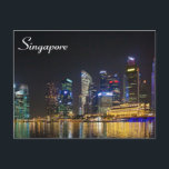 Landschaftliche Singapur Skyline Postkarte<br><div class="desc">Ein landschaftliches Stadtbild. Die Singapore Skyline am Abend mit vielen hochglanzvollen Gebäude, die hell erleuchtet sind mit ihren farbenfrohen Reflektionen, die das malerische Ufer entlang des Flusses Singapur erhellen.</div>