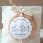 Las Vegas Skyline | Begrüßungsnachricht Runder Aufkleber<br><div class="desc">Erweitern Sie Ihre Hochzeitspakete oder Event-Gastgeschenke mit einem individuellen Set von Begrüßungsaufklebern! Diese eleganten, aber minimalistischen Aufkleber sind auf eine Hochzeit in der schönen Stadt Las Vegas zugeschnitten. Sie verfügen über eine moderne Skyline aus Deko, die den Namen der Stadt trägt und darunter integriert ist. Alle Elemente des Designs, einschließlich...</div>