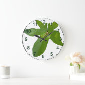 "Leafy Haven: Ein kleiner grüner Frosch auf einem Große Wanduhr (Zuhause)