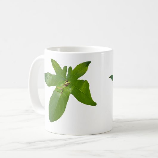 "Leafy Haven: Ein kleiner grüner Frosch auf einem Kaffeetasse (Vorderseite Links)