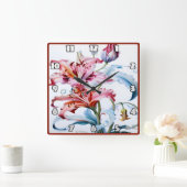 Lebhafte Lilien in Blüte vor weißem Hintergrund Quadratische Wanduhr (Zuhause)