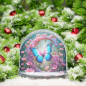 Lebhafter blauer Schmetterling auf einem blumenges Schneekugeln (Weihnachten)